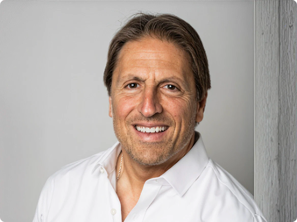 Casual portrait of a middle aged man in white, collared shirt, smiling at the camera