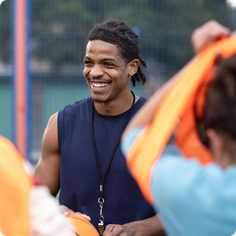 Young man in workout apparel coaching a group of young people