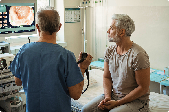 An man and his doctor look at images from his colonoscopy.