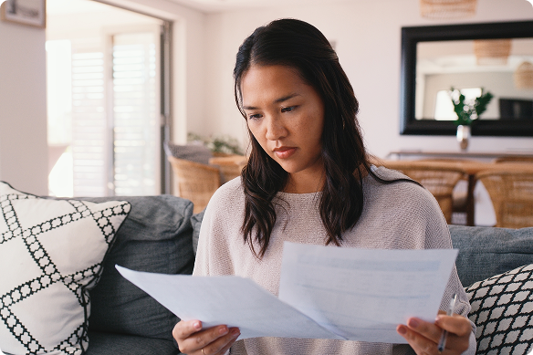Perplexed woman reviews insurance paperwork.
