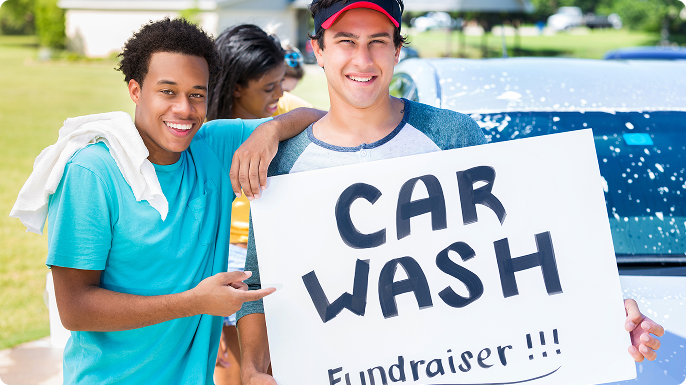 Two teenage boys at a car wash fundraiser.