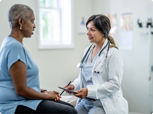 Woman talks with her doctor at her doctor’s office.