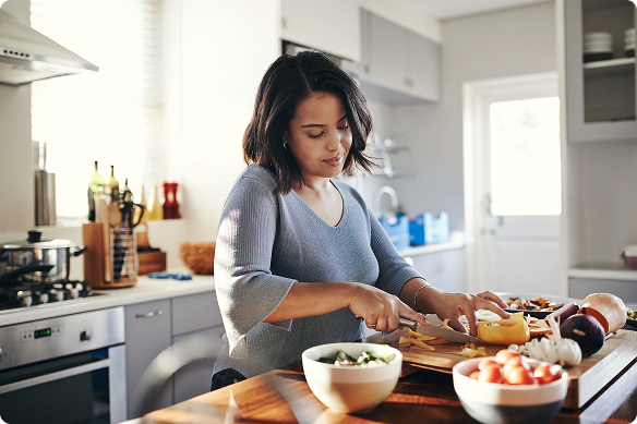 Woman prepares a meal with vegetables in her kitchen.