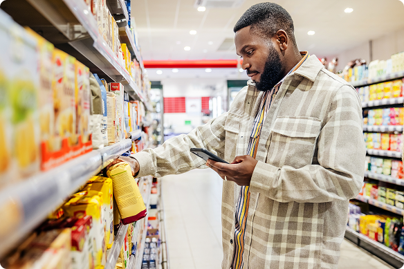 A man decides what flour to select as he reviews a recipe on his phone.