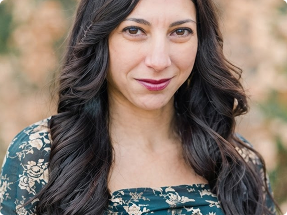 Portrait of a young woman in a floral dress looking at the camera and smiling