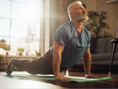 A middle-aged man practicing yoga in his home