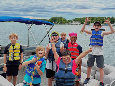 A group of happy younger boys on a boat.