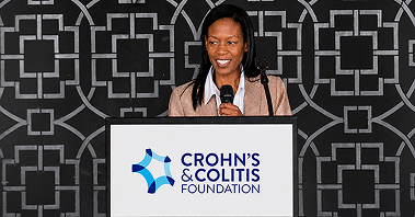 Young black woman speaking at a podium at a MyIBD Learning event
