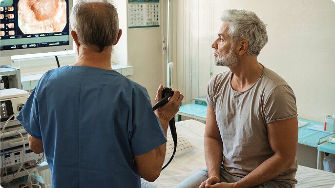A man and his doctor look at images from his colonoscopy.