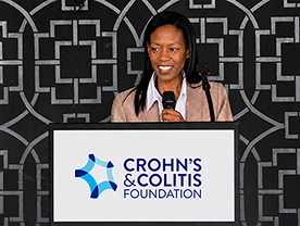 A woman speaks at the podium at a MyIBD Learning event