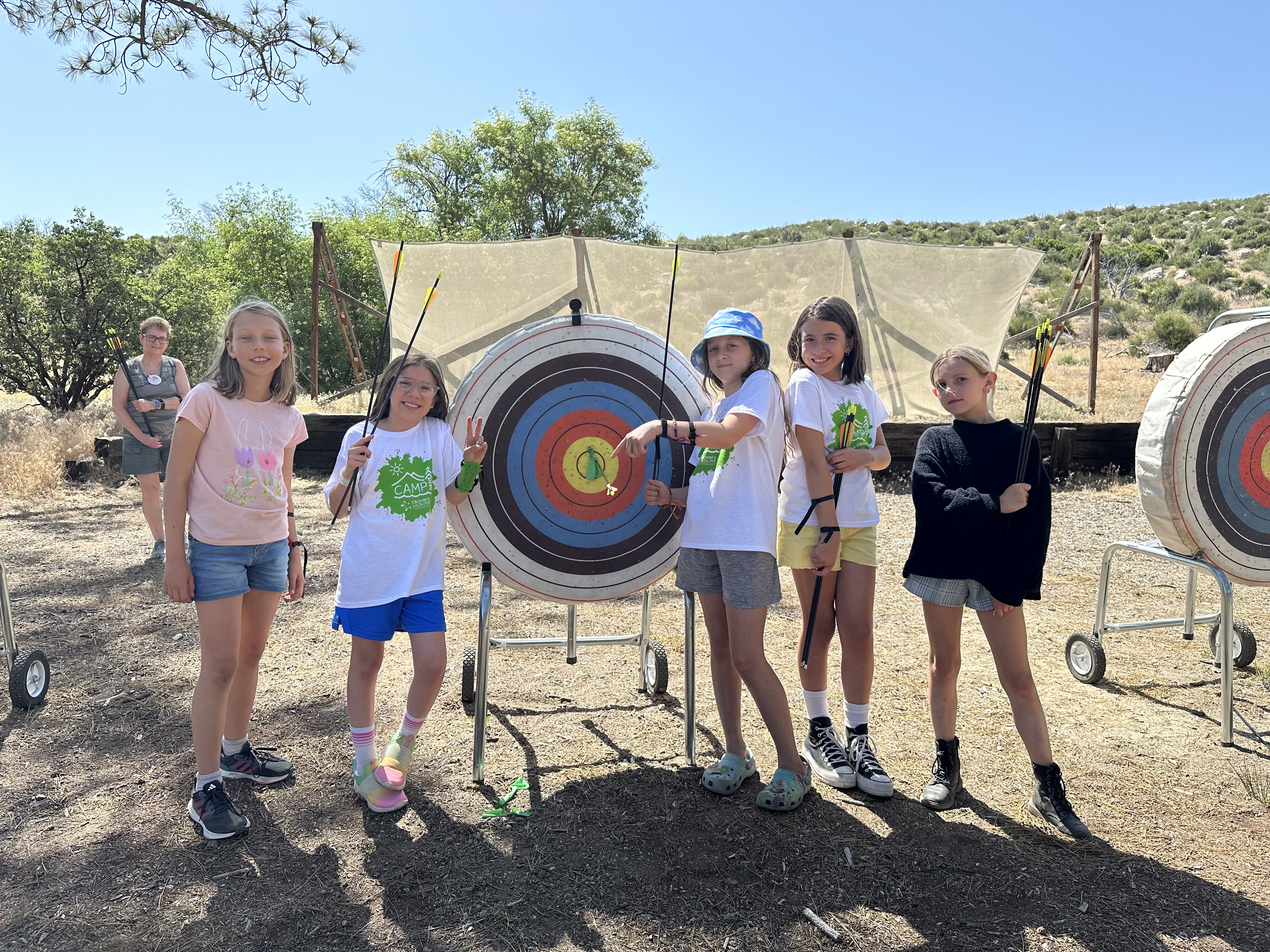 Campers pose next to an archery target