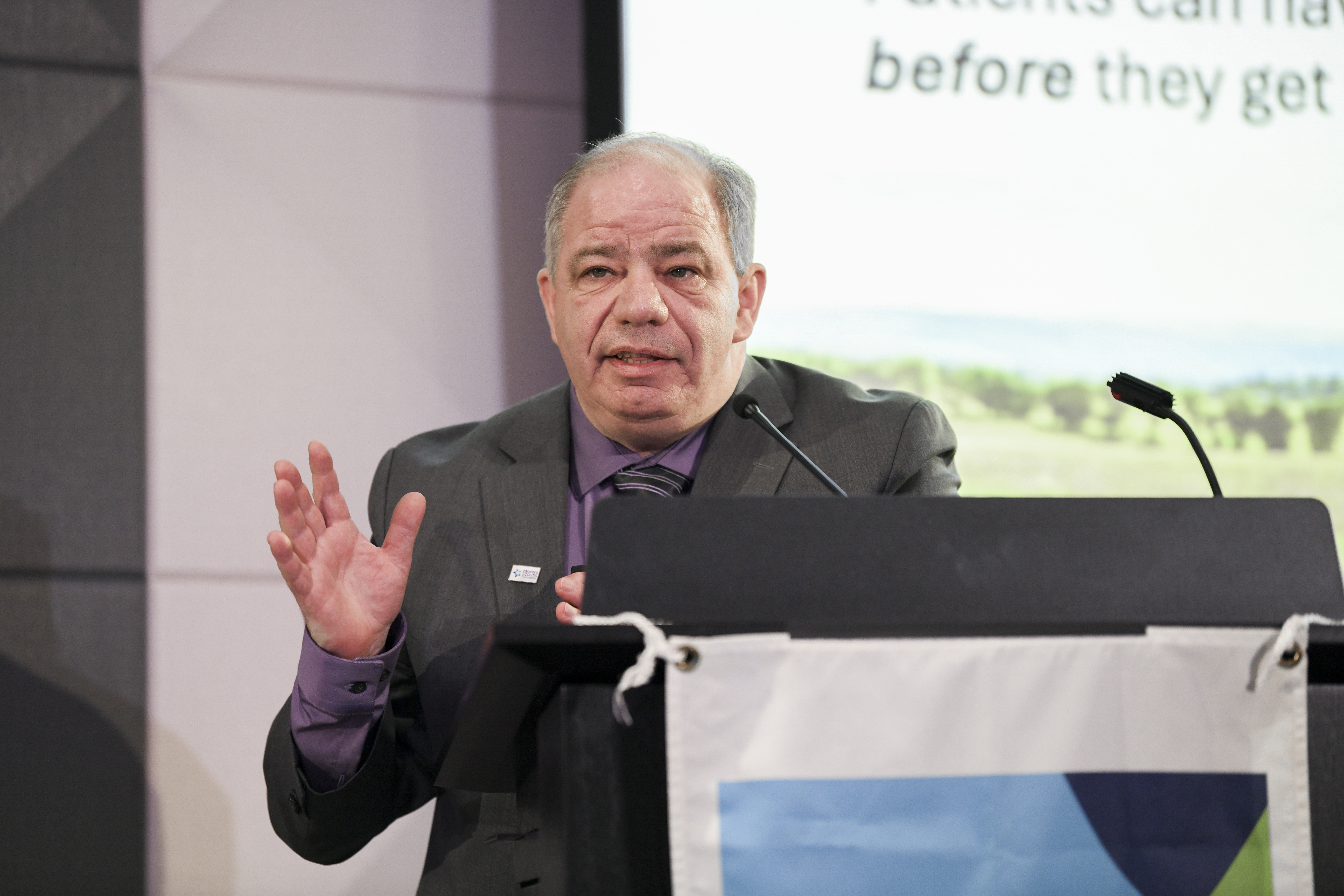 Dr. Peter Higgins delivers a keynote speech at a podium