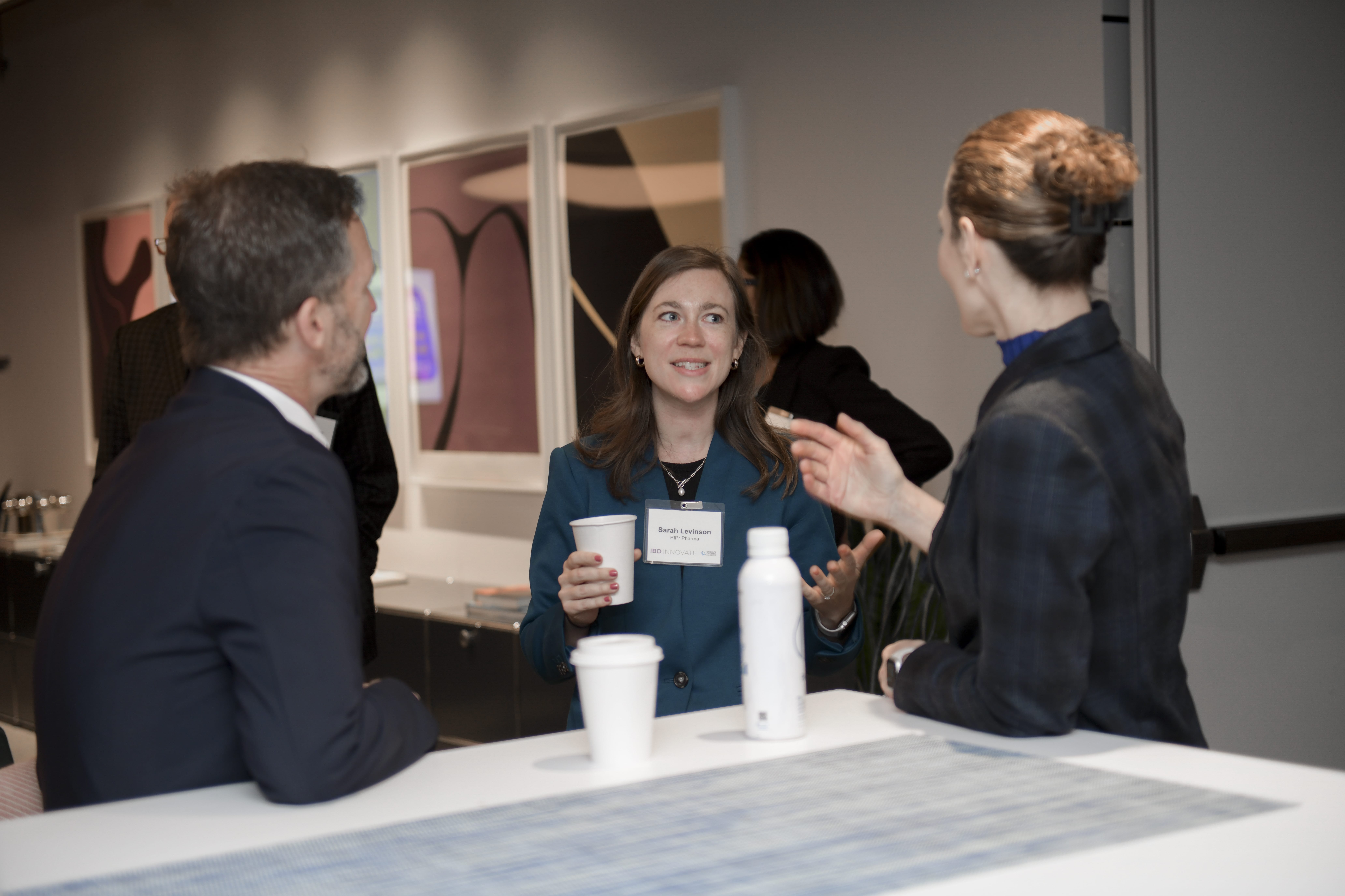 Three people stand gathered in conversation