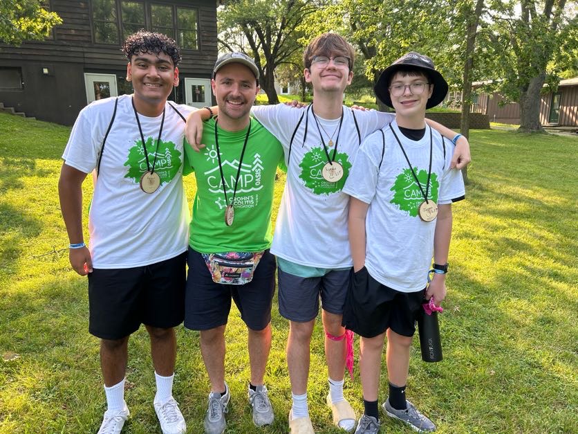 Campers smile and hug their counselor
