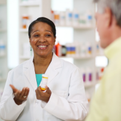 smiling pharmacist talking with man