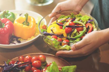 Person making a healthy summer salad for a gut friendly diet