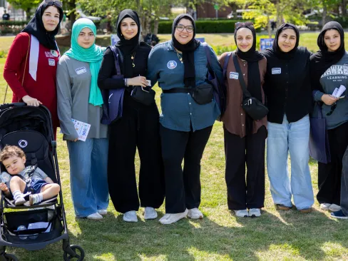 Group standing outside with a child in a stroller