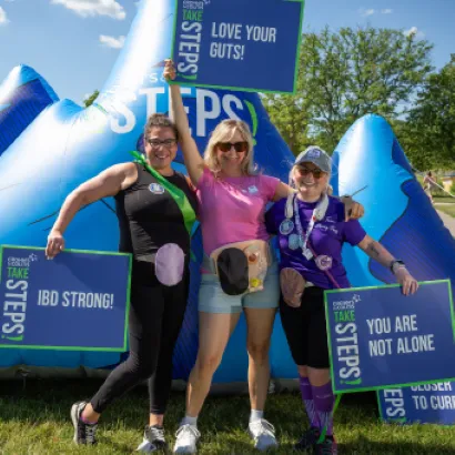 3 people holding "Take Steps" signs