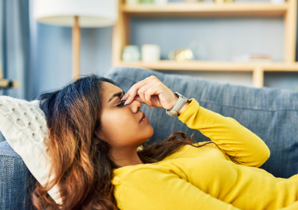 Woman lying on couch, sinus pain or headache