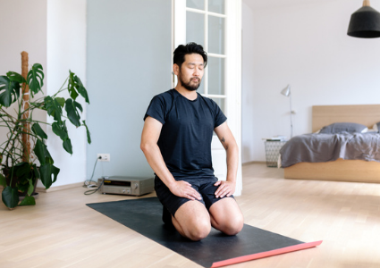 Man kneeling on yoga mat