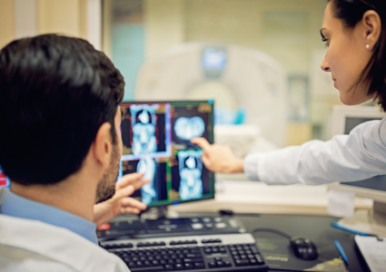 Healthcare professionals examining scans on a screen