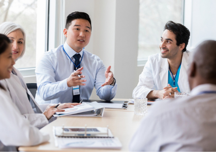 Physicians talking at a conference room table