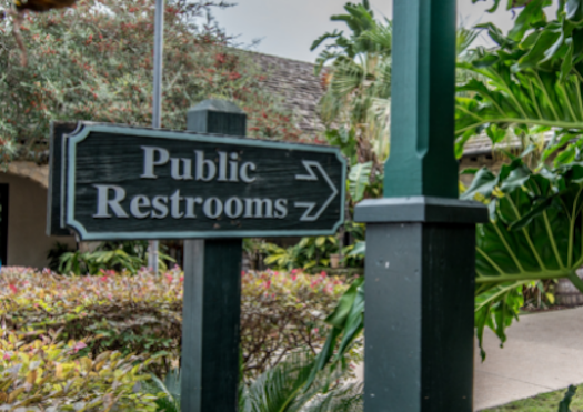 Green public restrooms sign with arrow