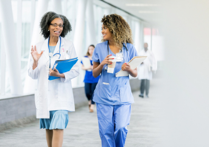 Two women doctors talking and walking
