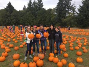 kids in a pumpkin patch holding pumpkins