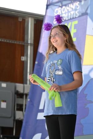 Taryn stands proudly on stage before the ribbon ceremony