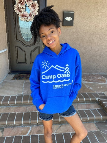 brave smiling girl wearing a blue camp oasis hoodie