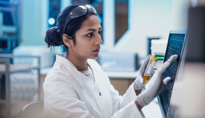 a researcher in her lab using equipment and holding a vile